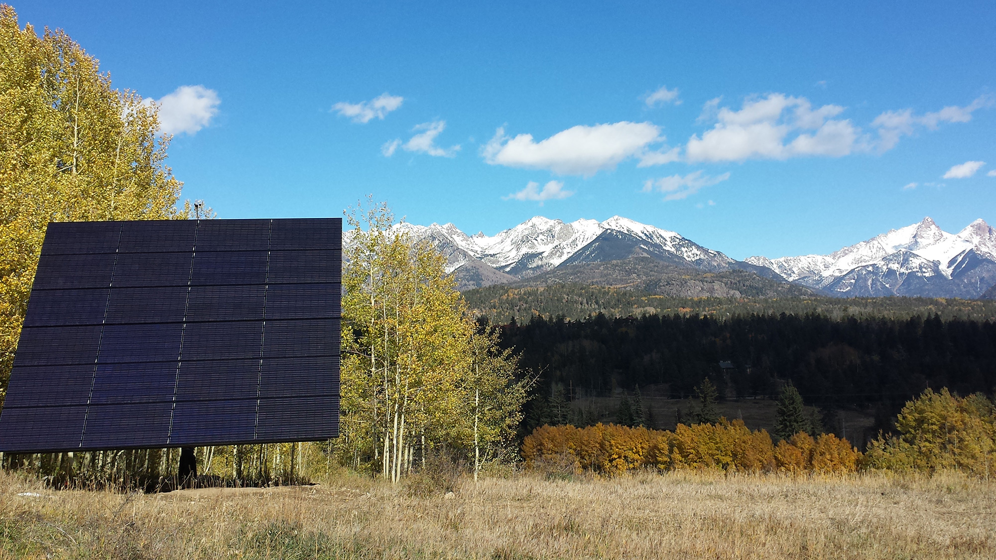 Solar panel with snowcapped mountains in the background.