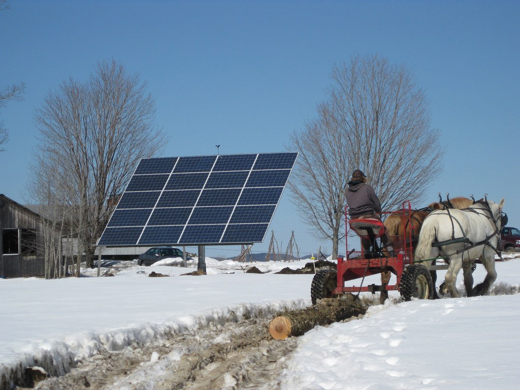 Solar panel next to a horse drawn log puller